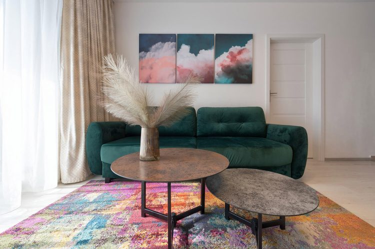 design apartament cluj, living cu canapea extensibila verde, masuta de cafea si tablouri colorate